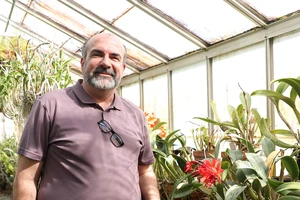 Nathan Bell, greenhouse supervisor and American Orchid Society trustee, in the orchid greenhouse.